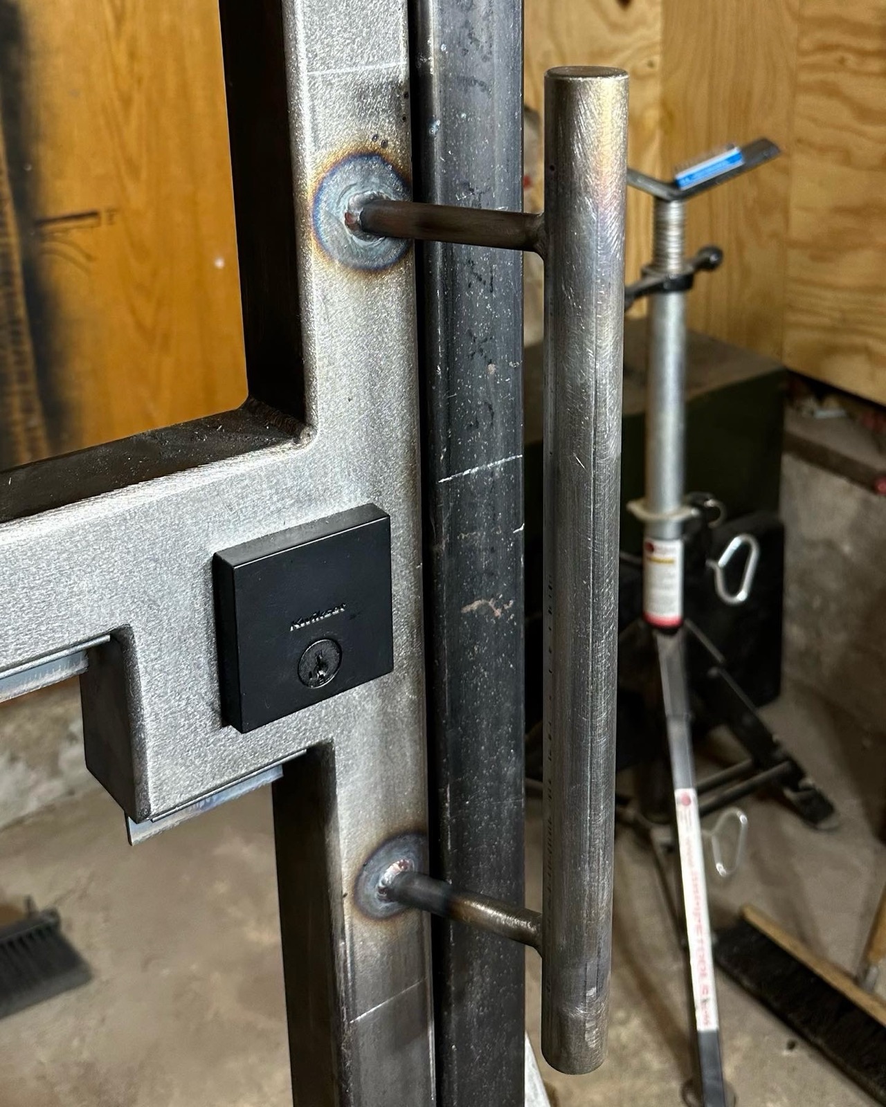 Custom steel door with welded bar pull and integrated deadbolt