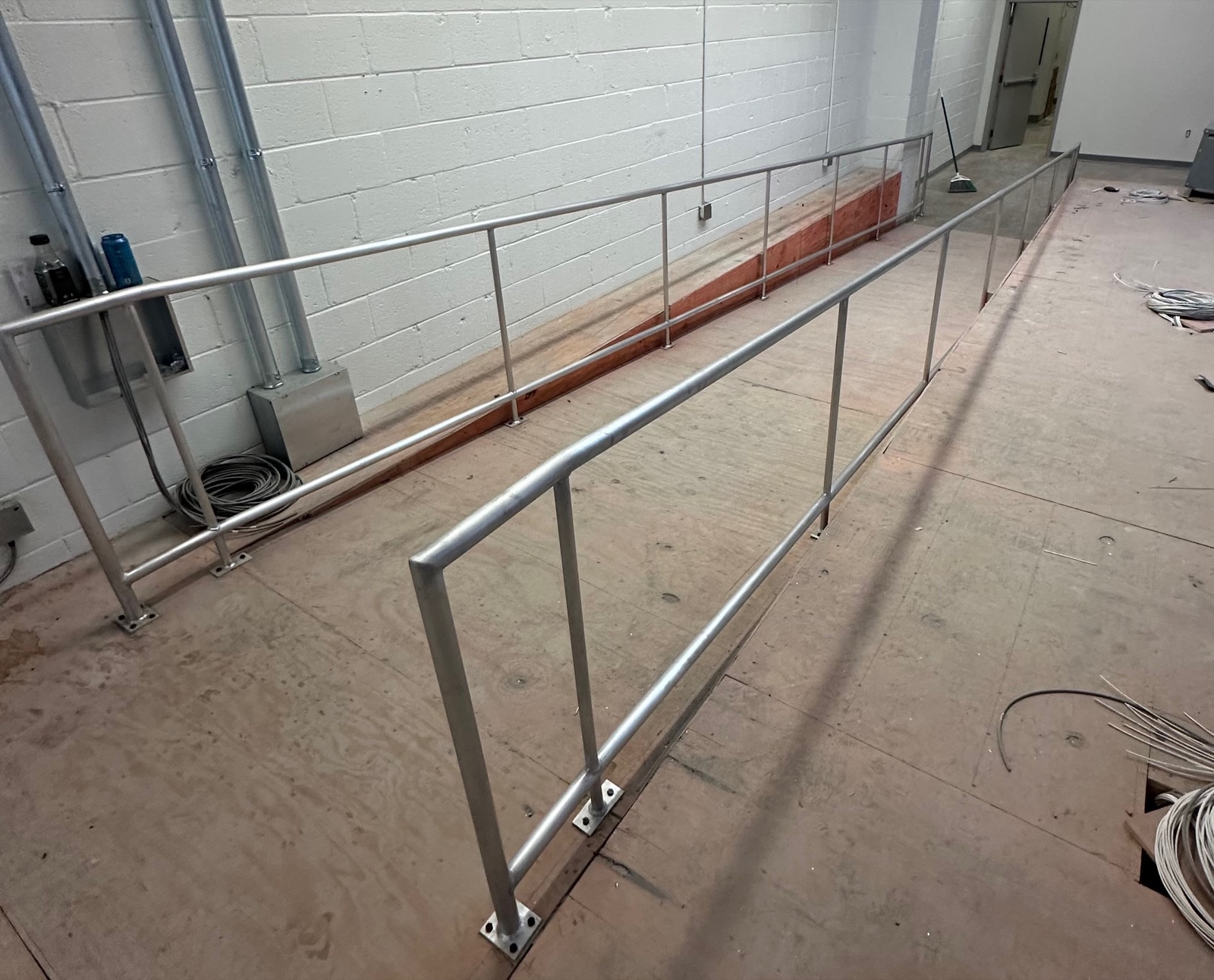 Long guardrail runs installed along a raised interior platform