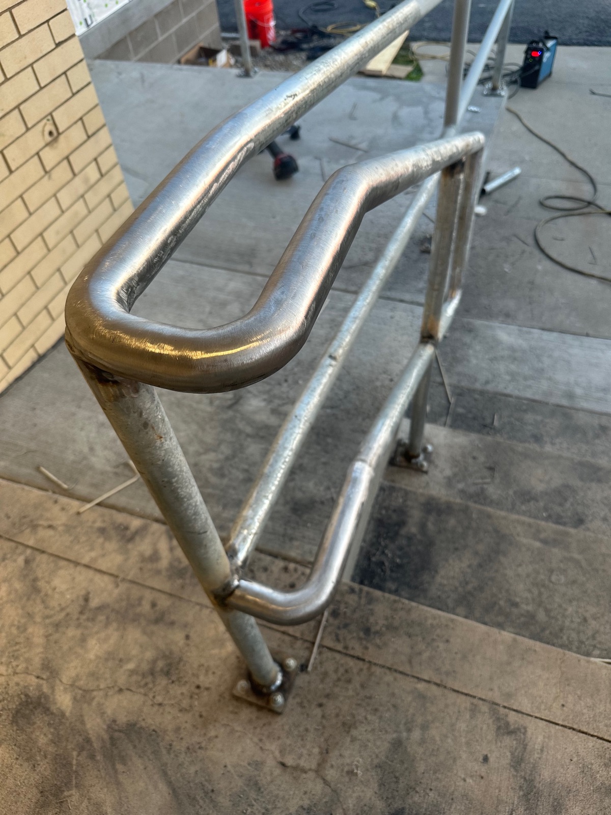 Continuous bent-tube stair handrail during on-site installation
