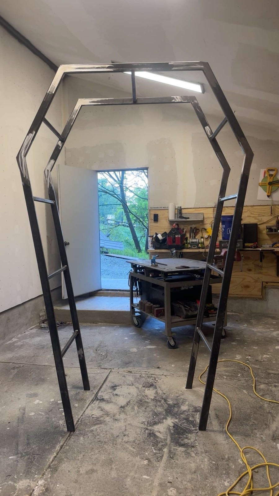 Raw steel hexagonal arch frame standing in the shop