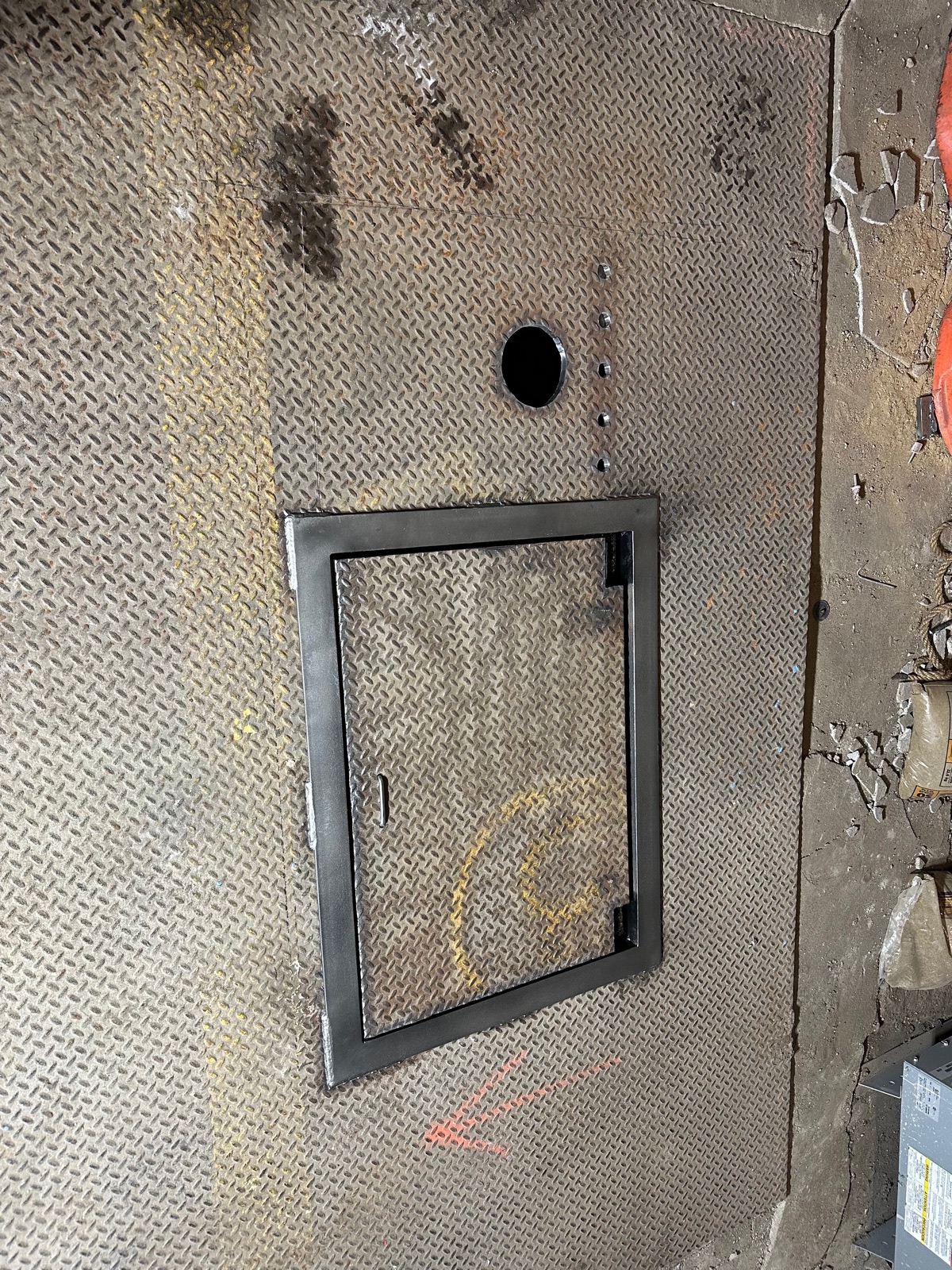 Flush-mounted hinged diamond-plate access hatch in an industrial floor